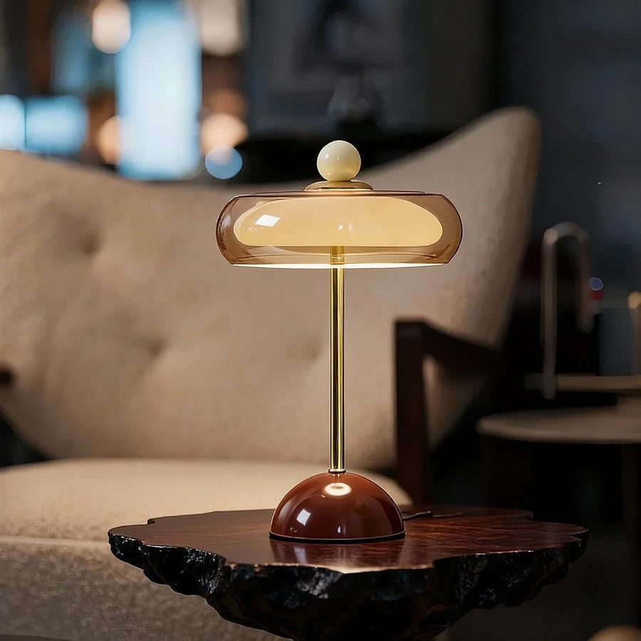 Brown Sorrel glass lamp glowing on a dark wood table
