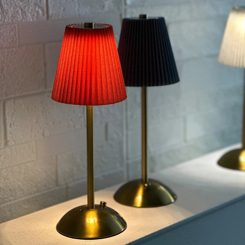 Red and black Nell cordless pleated lamps on a counter