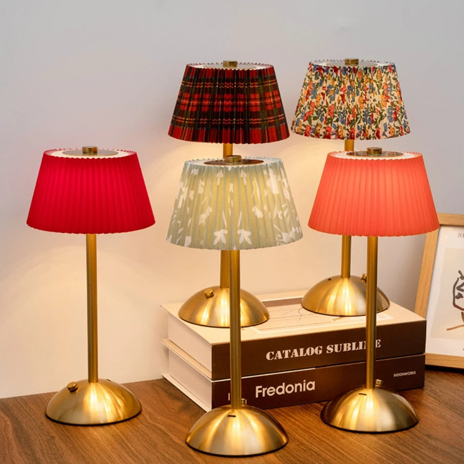 Five Elara cordless lamps with red, tartan, floral, and neutral pleated shades