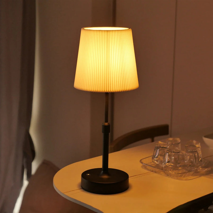 Black Linden cordless lamp with a pleated shade on a side table