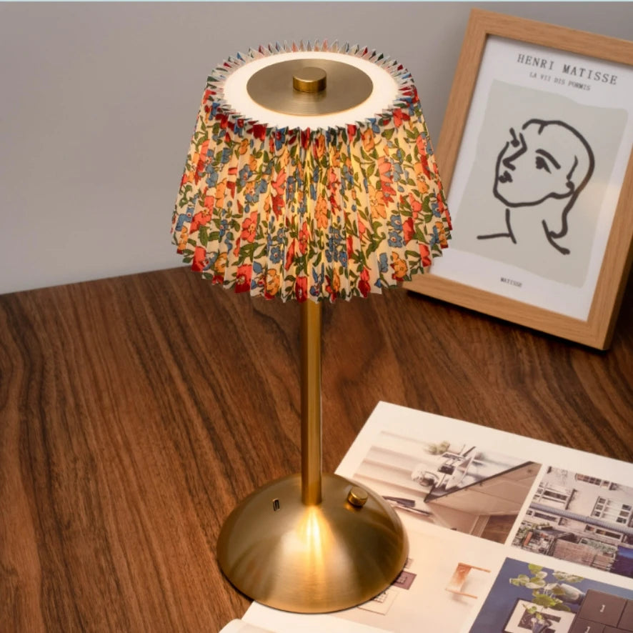 Elara cordless lamp with a floral pleated shade on a wood table