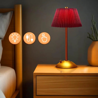 Red Elara cordless pleated lamp glowing on a bedside table