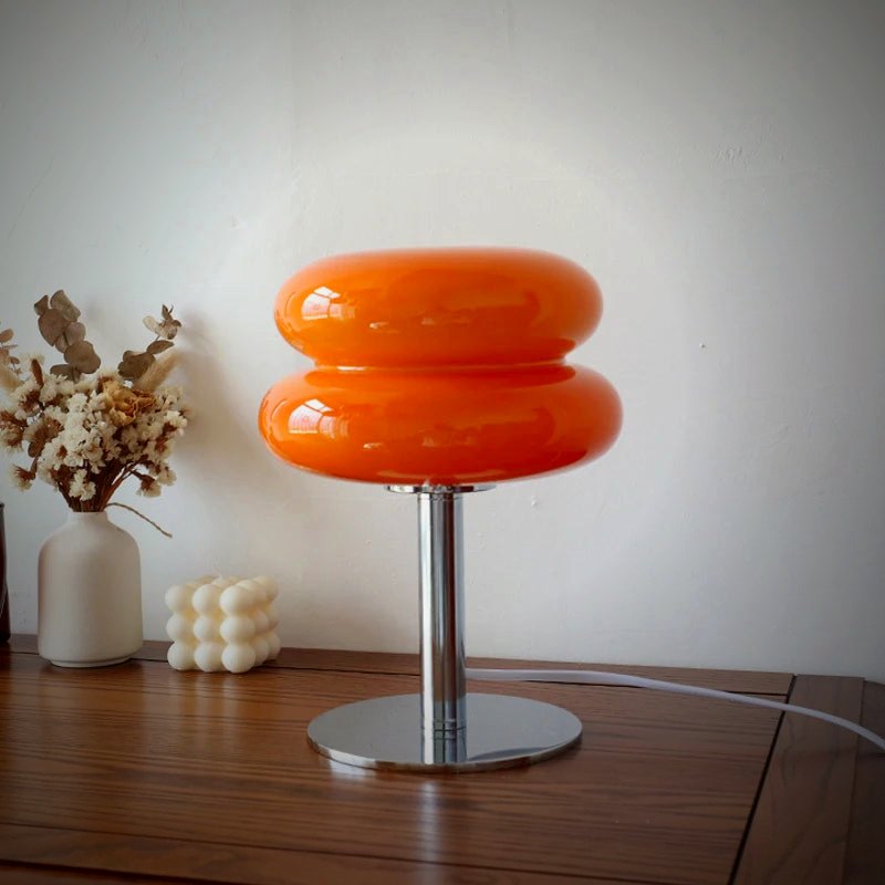 Ambra amber glass macaron lamp on a wood console