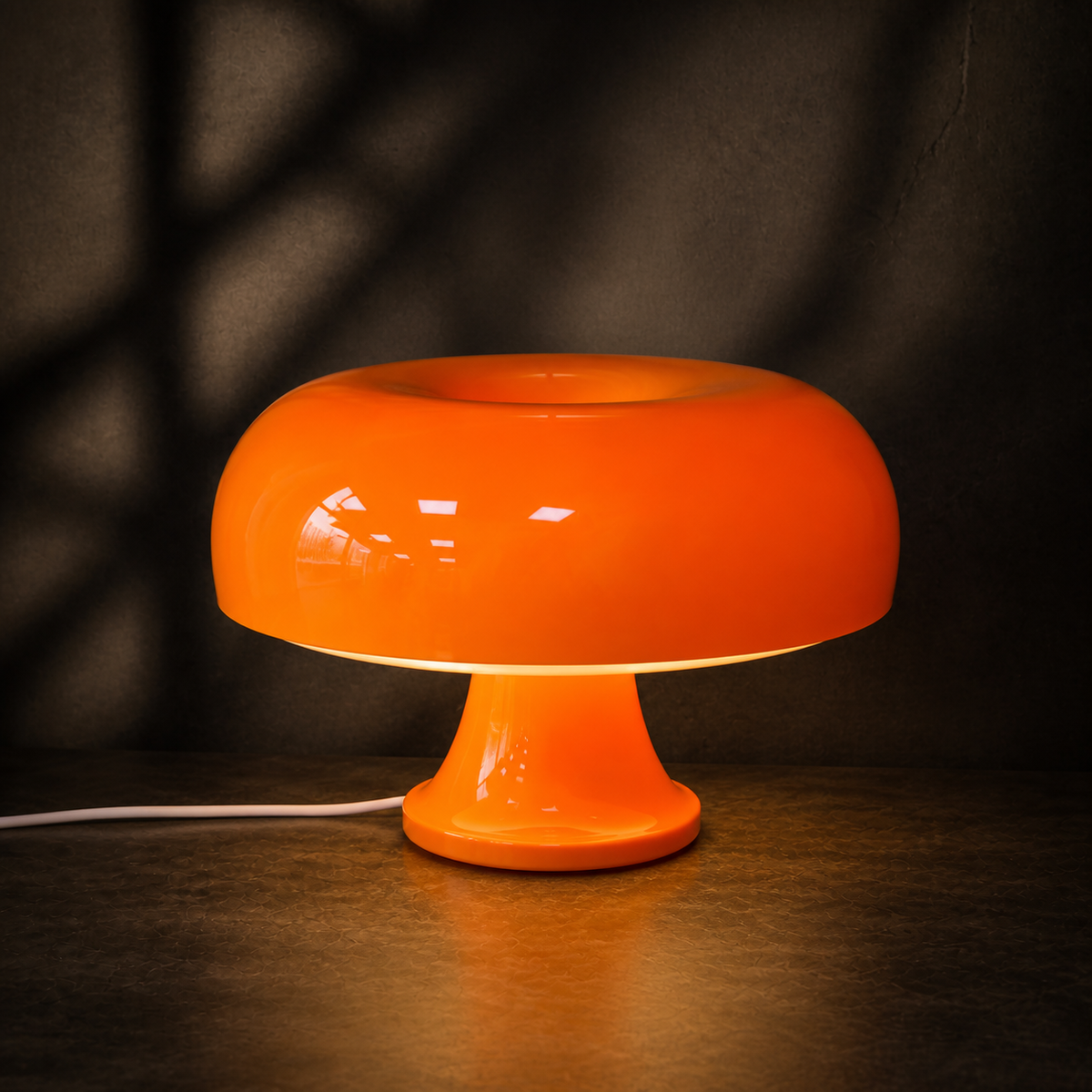 Orange Oslo mushroom table lamp glowing against a dark backdrop