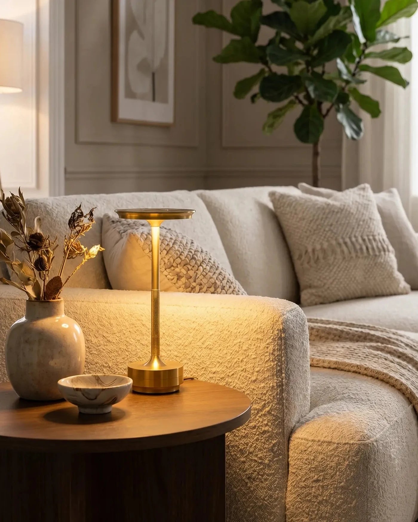 Astor cordless table lamp glowing beside an ivory sofa